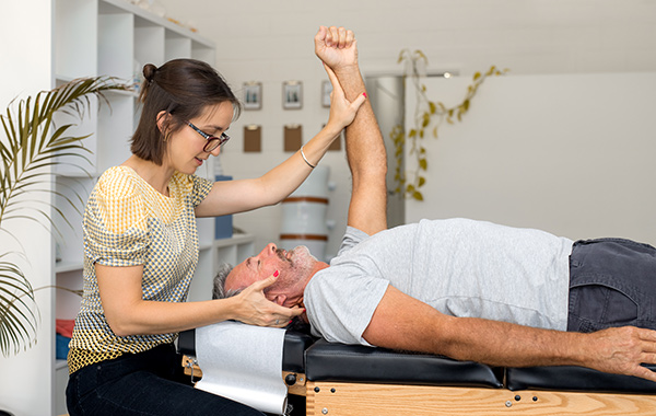 Male-Chiropractor-with-Specs-Explaining-to-Patient-about-the-Joint-Area-NoFrills-Chiropractic-Singapore